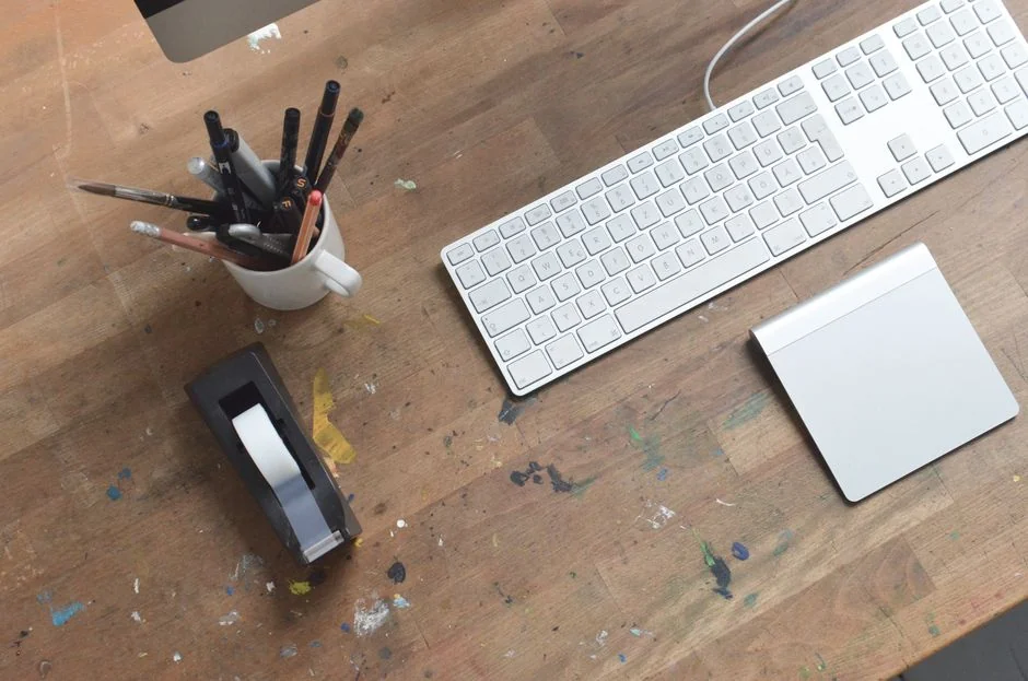 Un espace de travail dynamique avec un ordinateur portable, une tablette et une TV, baigné de lumières colorées.